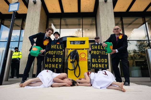 Climate Activists Pour Fake Blood over Protesters at Mock Petrol Pump outside Shell Centre, London, UK 6 May 2026 Activists lie on the ground in front of a mock petrol pump reading Oil Profit$$$ for Oil Bo$$es as they are doused in red liquid resembling blood outside the Shell Centre, London, UK, on 6 May 2026, during a Fossil Free London protest targeting Shell ahead of an expected jump in quarterly profits amid the US-Iran conflict., Credit:Pete Speller Avalon London, United Kingdom  Copyright: xPetexSpellerx xAvalonx 1096871556