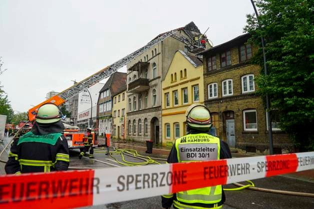 CNTV FEUERALARM- Die Hamburger Feuerwehr im Loesch Einsatz Drehleiter an der Brandstelle Dachstuhlbrand am 06.052026. Am Mittwoch morgen kam es aus noch unbekannten Gründen zum Brand eines Dachstuhls eines Mehrfamileinhauses in der Strasse Karnapp im Stadtteil Harburg. Die Feuerwehr gab dritten Alarm und setzte 3 Drehleitern zur Brandbekaempfung ein. Hamburg Deutschland