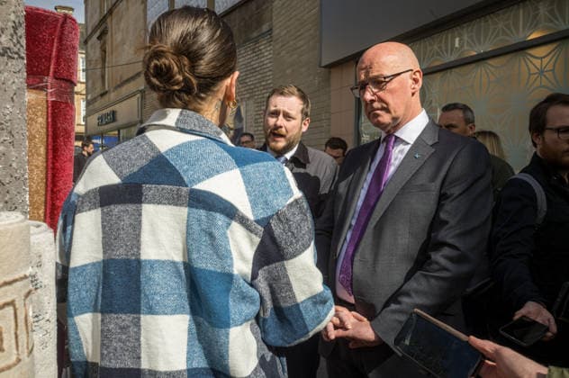 First Minister of Scotland John Swinney joins SNP candidate Alex Kerr campaigning in Hamilton - 06 May 2026 First Minister of Scotland John Swinney (right) and SNP candidate Alex Kerr (centre) meet a prospective voter in the constituency. The day before the Scottish parliamentary elections, First Minister of Scotland John Swinney visits Hamilton in South Lanarkshire, the constituency of SNP candidate Alex Kerr to kick off the final day of campaigning by meeting potential voters and owners of local businesses. Hamilton United Kingdom Copyright: xNeilxMiltonx xSOPAxImagesx L1000918