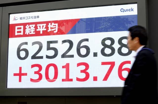 Nikkei hits record intraday high An electronic board in central Tokyo shows the 225-issue Nikkei Stock Average rising sharply to hit a record intraday high above 62,000 during morning trading on May 7, 2026.  A14AA0005513979P