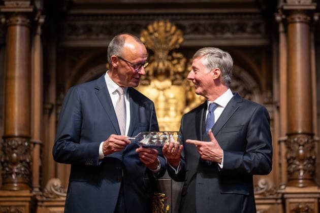 Friedrich Merz, Bundeskanzler, nach seiner Festrede im Hamburger Rathaus, mit Harald Vogelsang, Präsident Übersee-Club und Vorstandsvorsitzender Hamburger Sparkasse bei der Übergabe eines Buddelschiffs als traditionelles Gastgeschenk;76. Großer Übersee-Tag in Hamburg, April 2026 Festakt im Hamburger Rathaus, Hamburg Hamburg Deutschland Rathaus