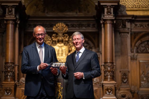 Friedrich Merz, Bundeskanzler, nach seiner Festrede im Hamburger Rathaus, mit Harald Vogelsang, Präsident Übersee-Club und Vorstandsvorsitzender Hamburger Sparkasse bei der Übergabe eines Buddelschiffs als traditionelles Gastgeschenk;76. Großer Übersee-Tag in Hamburg, April 2026 Festakt im Hamburger Rathaus, Hamburg Hamburg Deutschland Rathaus