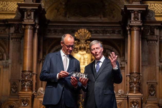 Friedrich Merz, Bundeskanzler, nach seiner Festrede im Hamburger Rathaus, mit Harald Vogelsang, Präsident Übersee-Club und Vorstandsvorsitzender Hamburger Sparkasse bei der Übergabe eines Buddelschiffs als traditionelles Gastgeschenk;76. Großer Übersee-Tag in Hamburg, April 2026 Festakt im Hamburger Rathaus, Hamburg Hamburg Deutschland Rathaus