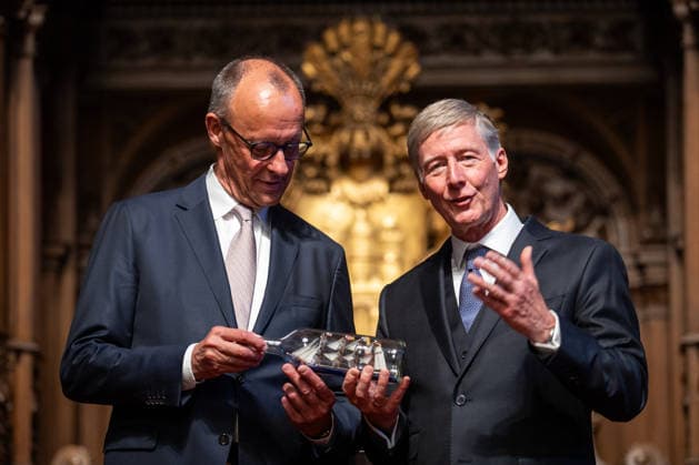 Friedrich Merz, Bundeskanzler, nach seiner Festrede im Hamburger Rathaus, mit Harald Vogelsang, Präsident Übersee-Club und Vorstandsvorsitzender Hamburger Sparkasse bei der Übergabe eines Buddelschiffs als traditionelles Gastgeschenk;76. Großer Übersee-Tag in Hamburg, April 2026 Festakt im Hamburger Rathaus, Hamburg Hamburg Deutschland Rathaus