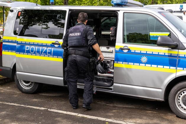 Großer Polizeieinsatz im Bereich Ulrich-Schwarz-Straße in Augsburg Pfersee. Ein Polizeibeamter entnimmt Ausrüstung aus einem Einsatzfahrzeug am Einsatzort.