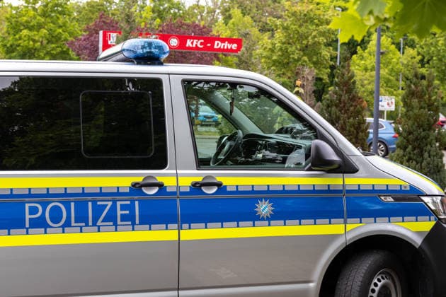 Großer Polizeieinsatz im Bereich Ulrich-Schwarz-Straße in Augsburg Pfersee. Ein Polizeifahrzeug steht während des laufenden Einsatzes nahe des Einsatzortes bereit.