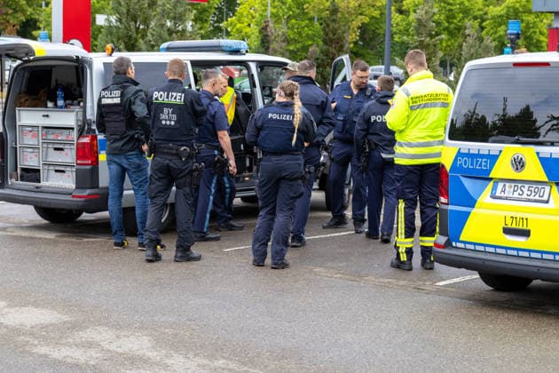 Großer Polizeieinsatz im Bereich Ulrich-Schwarz-Straße in Augsburg Pfersee. Mehrere Polizeikräfte koordinieren den laufenden Einsatz neben Einsatzfahrzeugen vor Ort.