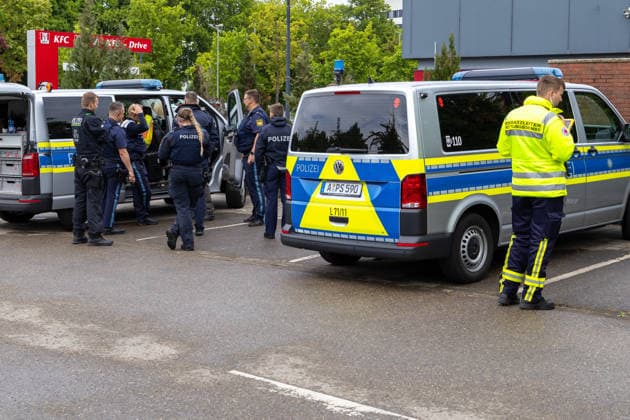 Großer Polizeieinsatz im Bereich Ulrich-Schwarz-Straße in Augsburg Pfersee. Mehrere Polizeikräfte koordinieren den laufenden Einsatz neben Einsatzfahrzeugen vor Ort.