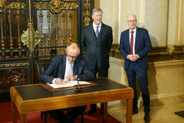 CNTV BUNDESKANZLER- Peter Tschentscher SPD Politiker und Erster Buergermeister von Hamburg Friedrich Merz CDU Politiker der Bundeskanzler mit Harald Vogelsang, Praesident Uebersee-Club und Vorstandsvorsitzender Hamburger Sparkasse beim Uebersee-Tag im Hamburger Rathaus am 07.05.2026 beim Eintragung in das Goldene Buch des Uebersee-Clubs Hamburg Deutschland