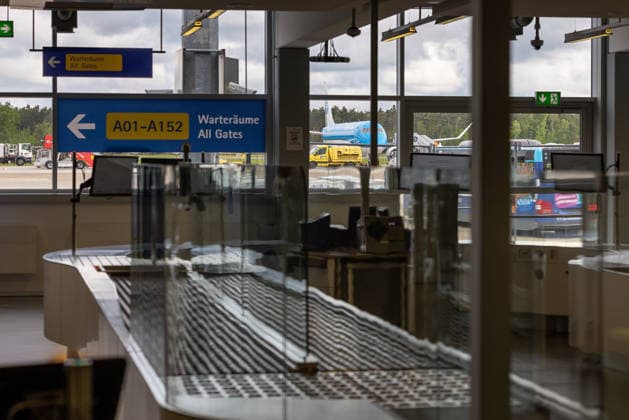 Eröffnung der neuen CT-Kontrollstelle am Airport Nürnberg, Nürnberg, 08.05.2026 Blick durch die neue CT-Kontrollstelle am Airport Nürnberg in Richtung Wartebereiche und Vorfeld. Im Vordergrund ist Fördertechnik der Fluggastkontrolle zu sehen, im Hintergrund ein Flugzeug auf dem Flughafengelände. Nürnberg Bayern Deutschland
