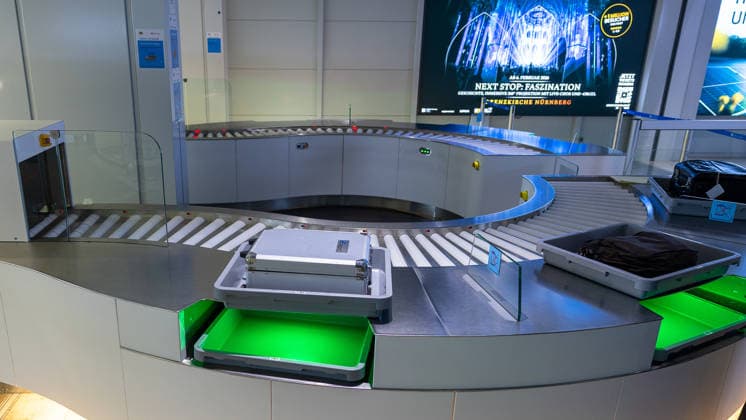 Eröffnung der neuen CT-Kontrollstelle am Airport Nürnberg, Nürnberg, 08.05.2026 Gepäckwannen mit Transportkoffer und Kleidungsstück auf der Fördertechnik der neuen CT-Kontrollstelle am Airport Nürnberg. Die Anlage dient der dreidimensionalen Kontrolle von Handgepäck an der Fluggastkontrolle. Nürnberg Bayern Deutschland