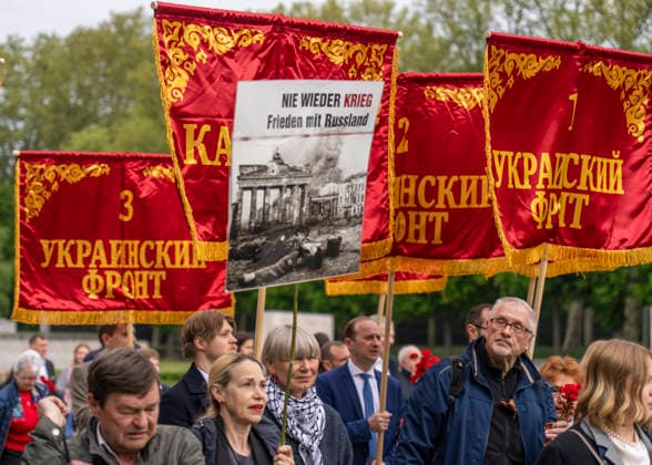 in Berlin lebende und arbeitende russische Bürger am 9. Mai, dem Tag des Sieges, am Sowjetischen Ehrenmal im Treptower Park in Berlin-Treptow. Die roten Fahnen weisen auf die verschiedenen sowjetischen Fronten im Krieg hin.