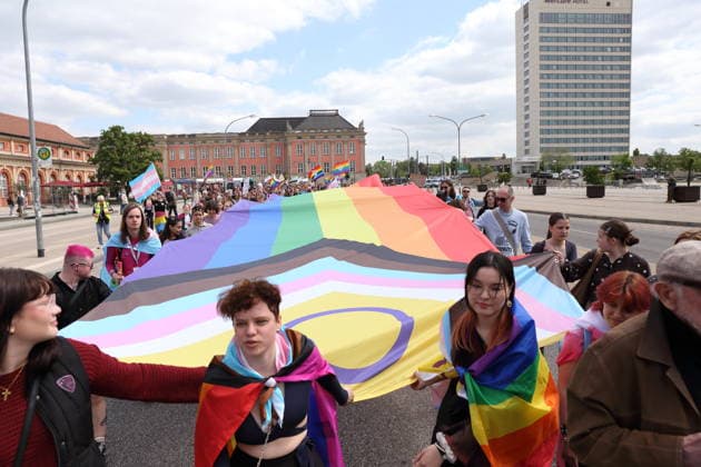 Menschen laufen mit Regenbogenfahne auf der Breiten Straße während einer Demo zum Christopher Street Day in Potsdam, 9. Mai 2026. CSD in Potsdam