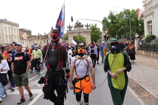 Menschen mit Masken laufen am Jägertor während einer Demo zum Christopher Street Day in Potsdam, 9. Mai 2026. CSD in Potsdam