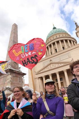 Menschen stehen mit Schild Liebe über Hass auf dem Alten Markt während einer Demo zum Christopher Street Day in Potsdam, 9. Mai 2026. CSD in Potsdam