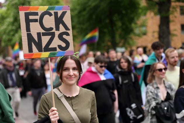 Ein Mensch läuft mit Schild FCK NZS in der Pappelallee während einer Demo zum Christopher Street Day in Potsdam, 9. Mai 2026. CSD in Potsdam
