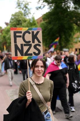 Ein Mensch läuft mit Schild FCK NZS in der Pappelallee während einer Demo zum Christopher Street Day in Potsdam, 9. Mai 2026. CSD in Potsdam