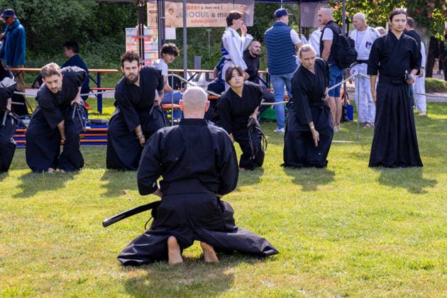 Teilnehmer einer japanischen Kampfkunst-Vorführung trainieren mit traditionellen Schwertern auf einer Freifläche. Traditionelles Japanisches Frühlingsfest im Botanischen Garten Augsburg. Das Event im Rahmen des 90-jährigen Garten-Jubiläums