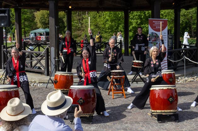 Teilnehmer einer japanischen Taiko-Trommelgruppe treten bei einer Kulturveranstaltung im Freien auf. Traditionelle Trommelrhythmen und choreografierte Bewegungen ziehen zahlreiche Besucher an. Traditionelles Japanisches Frühlingsfest im Botanischen Garten Augsburg. Das Event im Rahmen des 90-jährigen Garten-Jubiläums