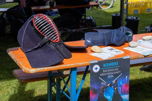 Kendo-Ausrüstung mit Schutzhelm und Handschuhen auf einem Tisch. Ein Hinweis auf die Bayerische Meisterschaft 2026 verweist auf Wettkampf und Training der japanischen Kampfkunst. Traditionelles Japanisches Frühlingsfest im Botanischen Garten Augsburg. Das Event im Rahmen des 90-jährigen Garten-Jubiläums