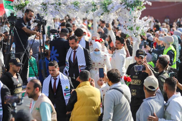 Mass Wedding Gaza City May 11 People and media workers record as brides and grooms walk through floral archways in a procession during a mass wedding celebration in Gaza City, Gaza Strip, on May 11, 2026. The mass wedding celebration for 50 grooms, identified by organizers as orphans of conflict casualties, is sponsored by the Turkish Humanitarian Relief Foundation (IHH). Gaza Gaza Strip Palestinian Territories Copyright: xAhmedxAlxArinix