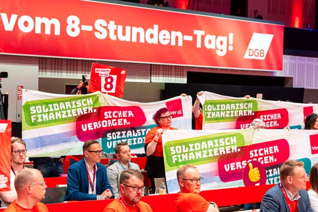 Protest beim DGB EUR, Deutschland, Berlin, 12.05.2026: Delegierte protestieren während der Rede des Bundeskanzlers - auf dem 23. DGB Bundeskongress. - Proud to be a Union Member - Schlagwort , Forderung zum Erhalt des 8-Stunden-Tag, Hände weg!