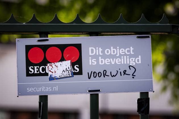 LOOSDRECHT - A defaced security sign a day after the fire at the emergency shelter for asylum seekers in Loosdrecht. At that building, there was a protest by several hundred people demonstrating against the arrival of asylum seekers at that location. ROBIN VAN LONKHUIJSEN ANP netherlands out - belgium out  Copyright: xx x558144952x originalFilename: 558144952.jpg