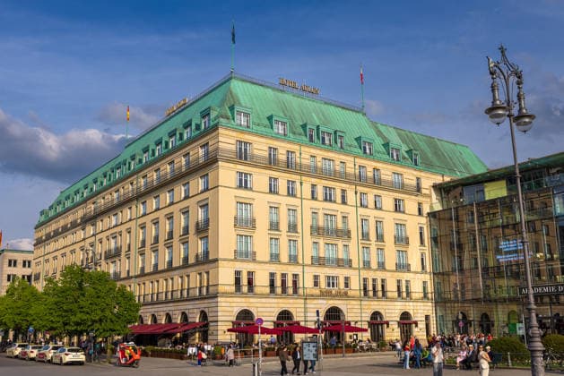 Hotel Adlon Kempinski Berlin Luxushotel am Pariser Platz, Berlin, 10.05.2026 Außenansicht des Hotel Adlon Kempinski am Pariser Platz in Berlin-Mitte nahe dem Brandenburger Tor. Die historisierende Fassade mit grünem Kupferdach und roter Außengastronomie. Rechts die Akademie der Künste. Zahlreiche Besucher beleben den Platz. Berlin-Mitte Berlin Deutschland