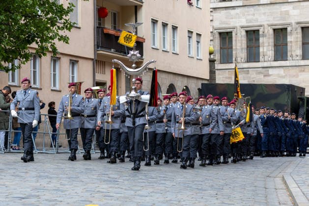 Öffentliches Gelöbnis der Bundeswehr auf dem Sebalder Platz, Nürnberg, 13.05.2026 Das Heeresmusikkorps Veitshöchheim marschiert mit Tambourmajor, Blechbläsern und Fahnenträger in grauem Dienstanzug und rotem Barett auf dem Sebalder Platz ein. Dahinter folgt die Ehrenformation der Bundeswehr. Nürnberg Altstadt - Saint Sebald Bayern Deutschland