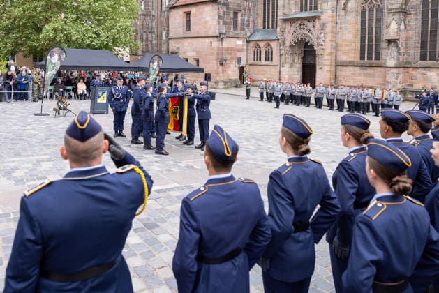 Öffentliches Gelöbnis der Bundeswehr auf dem Sebalder Platz, Nürnberg, 13.05.2026 Gesamtansicht des Fahneneid-Moments: Rekrutinnen und Rekruten der Luftwaffe berühren die Truppenfahne vor der Sebalduskirche. Im Hintergrund das Heeresmusikkorps Veitshöchheim und zahlreiche Gäste. Nürnberg Altstadt - Saint Sebald Bayern Deutschland
