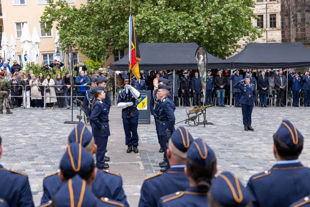 Öffentliches Gelöbnis der Bundeswehr auf dem Sebalder Platz, Nürnberg, 13.05.2026 Die Fahnenabordnung der Luftwaffe steht nach dem Feierlichen Gelöbnis mit Truppenfahne in der Platzmitte. Offiziere salutieren, im Hintergrund zahlreiche stehende militärische und zivile Gäste. Nürnberg Altstadt - Saint Sebald Bayern Deutschland