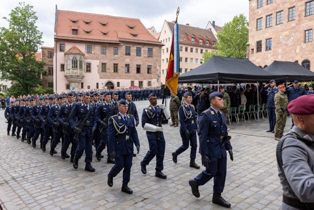 Öffentliches Gelöbnis der Bundeswehr auf dem Sebalder Platz, Nürnberg, 13.05.2026 Die Ehrenformation der Luftwaffe marschiert mit Truppenfahne und geschultertem Gewehr nach dem Feierlichen Gelöbnis aus. Offiziere und Gäste salutieren beim Vorbeimarsch. Nürnberg Altstadt - Saint Sebald Bayern Deutschland