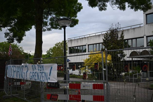 Violent Protest at Asylum Shelter in Loosdrecht LOOSDRECHT, NETHERLANDS - MAY 13: A view of the asylum shelter with a banner hung on the barriers as police officers and emergency services respond after a protest outside a temporary asylum shelter turned violent, leading to several arrests after demonstrators reportedly set fires and launched projectiles near the facility in Loosdrecht, Netherlands, on May 13, 2026. Mouneb Taim Anadolu Loosdrecht Netherlands. Editorial use only. Please get in touch for any other usage.  Copyright: x2026xAnadoluxMounebxTaimx
