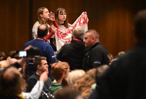 Proteste mit Banner Klimakrise merzt uns aus bei einer Podiumsveranstaltung zum Thema Gemeinsam Zukunft gestalten mit Bundeskanzler Friedrich Merz (CDU) beim Katholikentag in Wuerzburg (im Foto vom 15.05.2026). Bis Sonntag werden beim 104. Deutschen Katholikentag unter dem biblischen Leitwort Hab Mut, steh auf! mehrere zehntausend Teilnehmende zu insgesamt 900 Veranstaltungen erwartet. Das Treffen soll angesichts von Krieg, Klimawandel, sozialer Spaltung sowie Vertrauenskrisen in Politik und Kirche dazu ermutigen, nach Wegen fuer die Zukunft zu suchen. (Siehe epd-Meldung vom 14.05.2026) EDITORIAL USE ONLY