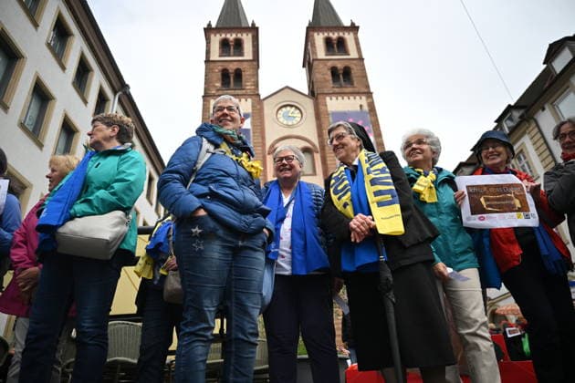 Menschenkette von katholischen Reformgruppen zwischen dem Kiliansdom (Foto) und der Augustiner Kirche beim Katholikentag in Wuerzburg (Foto vom 15.05.2026). Mit dem Aufruf Gemeinsam fuer mutigere Reformen! formulieren 30 katholische Organisationen kirchliche und gesellschaftliche Handlungsfelder, die das Leitwort Habt Mut, steht auf! des Wuerzburger Katholikentages konkret werden lassen. Bis Sonntag werden beim 104. Deutschen Katholikentag unter dem biblischen Leitwort Hab Mut, steh auf! mehrere zehntausend Teilnehmende zu insgesamt 900 Veranstaltungen erwartet. Das Treffen soll angesichts von Krieg, Klimawandel, sozialer Spaltung sowie Vertrauenskrisen in Politik und Kirche dazu ermutigen, nach Wegen fuer die Zukunft zu suchen. (Sieh Copyright: epd-bild DanielxPeter epd-Katholikentag_Wuerzburg118-kopieren.jpeg