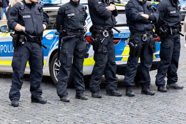Demonstration gegen die aktuelle Bundesregierung unter Bundeskanzler Friedrich Merz in Augsburg. Unter dem Motto: Merz muss weg! Mehrere Polizeibeamte im Einsatz vor einem Streifenwagen