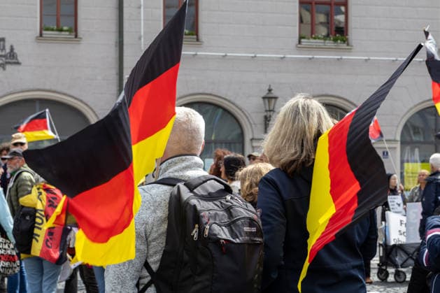 Demonstration gegen die aktuelle Bundesregierung unter Bundeskanzler Friedrich Merz in Augsburg. Unter dem Motto: Merz muss weg! Mehrere Demonstrationsteilnehmer tragen und schwenken Deutschlandflaggen während der Kundgebung im Stadtzentrum von Augsburg
