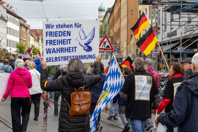 Demonstration gegen die aktuelle Bundesregierung unter Bundeskanzler Friedrich Merz in Augsburg. Unter dem Motto: Merz muss weg! Teilnehmerin mit Schild Banner: Wir stehen für FRIEDEN FREIHEIT WAHRHEIT SELBSTBESTIMMUNG