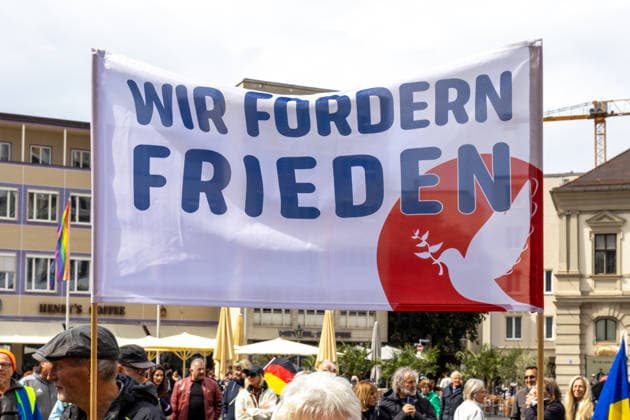 Demonstration gegen die aktuelle Bundesregierung unter Bundeskanzler Friedrich Merz in Augsburg. Unter dem Motto: Merz muss weg! Banner bzw. Plakat: WIR FORDERN FRIEDEN