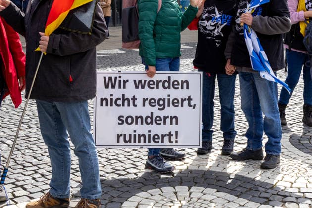 Demonstration gegen die aktuelle Bundesregierung unter Bundeskanzler Friedrich Merz in Augsburg. Unter dem Motto: Merz muss weg! Frau hält Plakat mit Aufschrift: WIR WERDEN NICHT REGIERT, SONDERN RUINIERT!