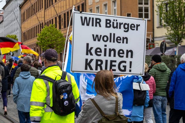 Demonstration gegen die aktuelle Bundesregierung unter Bundeskanzler Friedrich Merz in Augsburg. Unter dem Motto: Merz muss weg! Menschenmenge mit Plakat: WIR BÜRGER WOLLEN KEINEN KRIEG!
