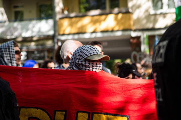 May 16, 2026, Berlin, Berlin, Germany: A protester protects his identity by covering his face with a Palestinian keffiyeh behind a red banner during the Nakba 78 demonstration in Berlin. Berlin Germany  - ZUMAc291 20260516_zip_c291_005 Copyright: xMariaxCastrox