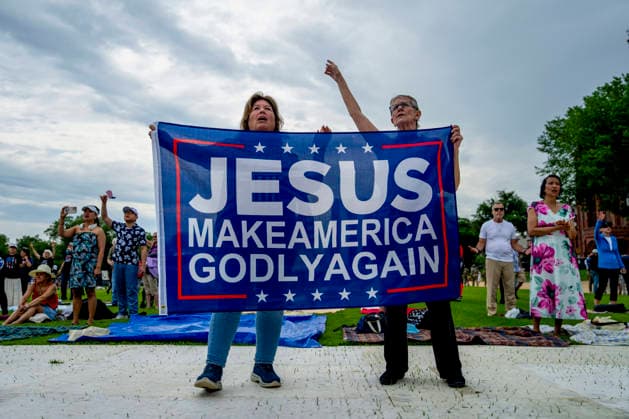 People hold a Jesus Make America Godly Again flag while worshipping during Rededicate 250 on the National Mall in Washington, DC on Sunday, May 17, 2026. The event, organized by Freedom 250 and the White House Faith Office, will feature political and faith leaders honoring 250 years of American history and encourage prayer or the country s next 250 years.  WAP20260517328 BONNIExCASH