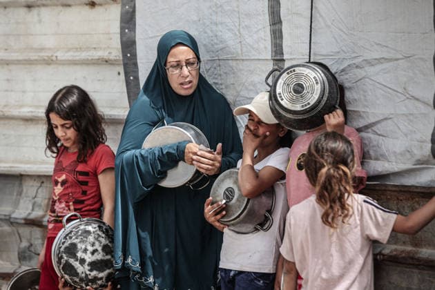 Hot meals distributed to displaced Palestinians in Gaza GAZA CITY, GAZA, PALESTINE - MAY 18: Displaced Palestinians, including many children, wait in long queues to receive hot meals distributed by a charitable organization at Bureijj Refugee Camp in Gaza City, Gaza, Palestine on May 18, 2026. Due to the ongoing Israeli blockade and severe restrictions on the entry of humanitarian aid, the region continues to face a critical food shortage, leaving thousands of families reliant on irregular aid distributions. Moiz Salhi Anadolu Gaza City Gaza. Editorial use only. Please get in touch for any other usage.  Copyright: x2026xAnadoluxMoizxSalhix