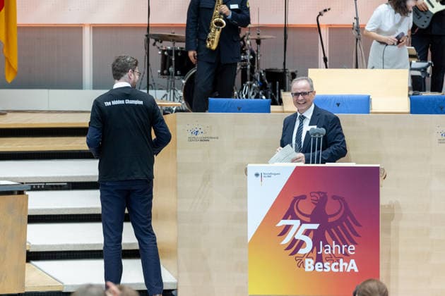 Festakt 75 Jahre Beschaffungsamt des BMI in Bonn Präsident des BeschA Dr. Alexander EISVOGEL überreicht Staatssekretär Sebastian WÜSTE ein T-Shirt des Beschaffungsamtes mit der Aufschrift The hidden Chanpion - Festakt zum 75-jährigen Bestehen des Beschaffungsamtes des BMI im ehemaligen Plenarsaal des Deutschen Bundestages, der heute Teil des World Conference Center Bonn ist. Das Beschaffungsamt gilt als größter ziviler Beschaffer des Bundes und beschafft unter anderem für das Technische Hilfswerk. Bonn Gronau Rheinland-Pfalz Deutschland Copyright: xMarcxJohnx