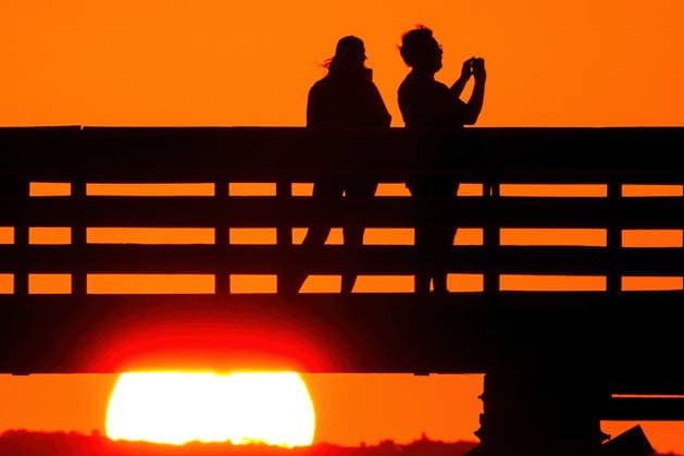 May 19, 2026, Isle Of Palms, Sc, United States: A couple takes photos from IOP Fishing Pier silhouetted by the sunrise over the Atlantic Ocean, May 19, 2026 in Isle of Palms, South Carolina. Isle Of Palms United States  - ZUMAe02_ 20260519_zaf_e02_003 Copyright: xRichardxEllisx