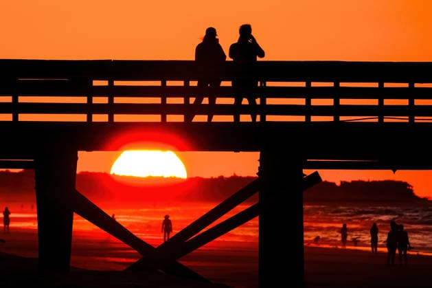 May 19, 2026, Isle Of Palms, Sc, United States: A couple takes photos from IOP Fishing Pier silhouetted by the sunrise over the Atlantic Ocean, May 19, 2026 in Isle of Palms, South Carolina. Isle Of Palms United States  - ZUMAe02_ 20260519_zaf_e02_002 Copyright: xRichardxEllisx