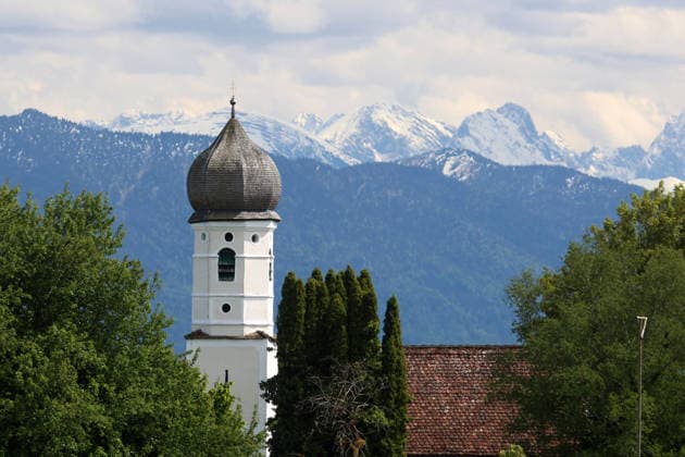 Ein Frühsommertag bei Tutzing (Landkreis Starnberg). Hier der Blick von der Ilkahöhe auf den Kirchturm des Nikolauskircherl, im Hintergrund das Karwendel