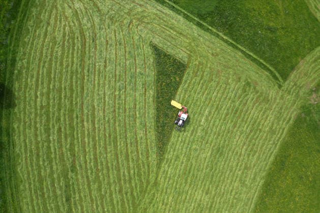 Luftaufnahme. Fruehling (Frühling) im Siegerland. Eine saftig gruene (grüne) Wiese wird von einem Traktor mit einem Maehwerk (Mähwerk) bei Siegen-Oberschelden gemaeht (gemäht). Fruehling (Frühling) im Siegerland am 23.05.2026 in Siegen Deutschland.
