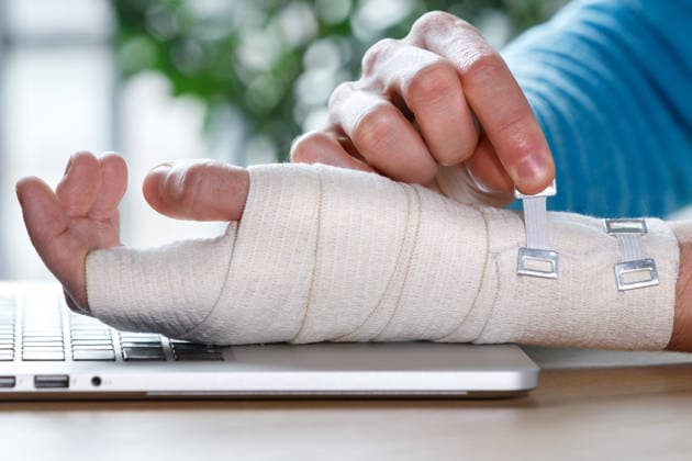 Ein Mann, der sein schmerzendes Handgelenk mit einer orthopädischen Bandage umwickelt Close up of man arms wrapping his painful wrist with Flexible elastic supportive orthopedic bandage caused by prolonged work on laptop. Carpal tunnel syndrome, arthritis, arm sprain concept. (License=RF) ,model released, Symbolfoto Copyright: xZoonar.com DmitriixMarchenkox xEnvatox 25067608 ,model released, Symbolfoto ,property released